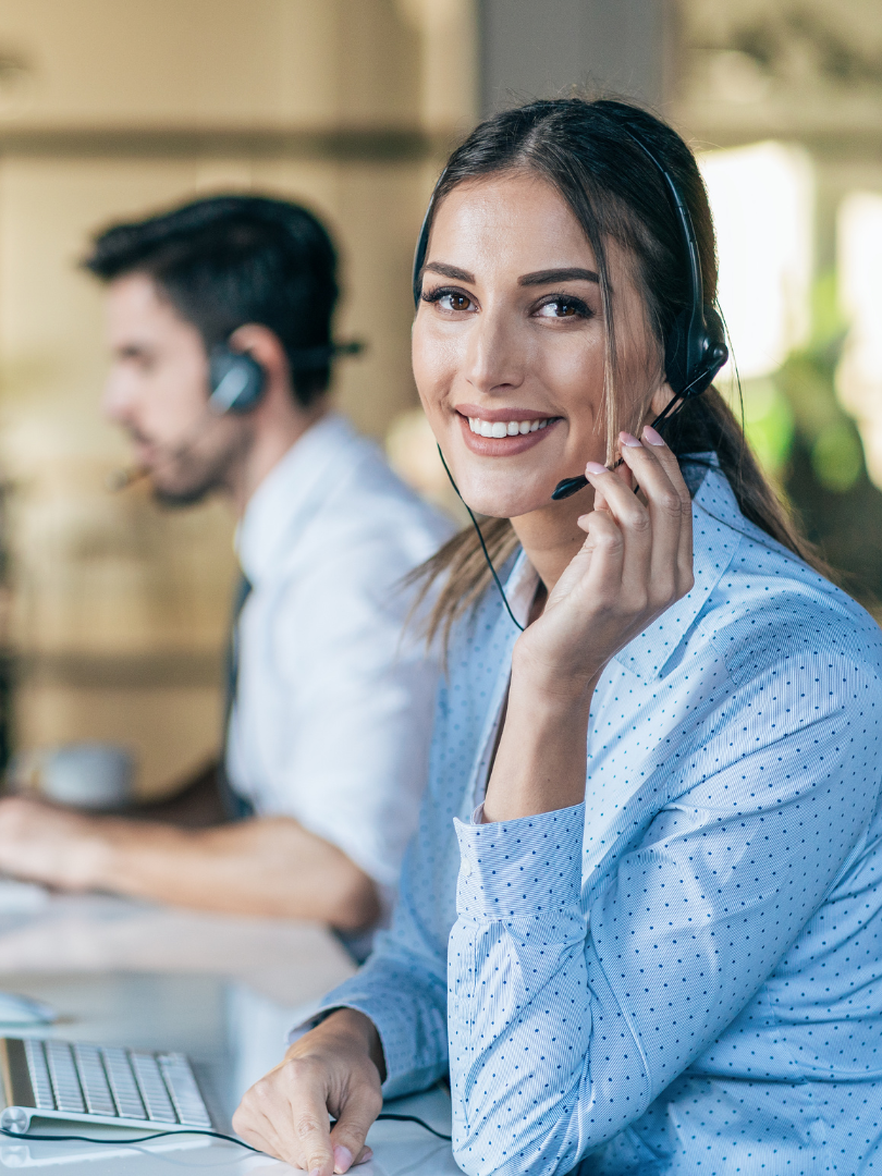 Insta-Cust Smiling customer service agent with a headset on, working at her computer